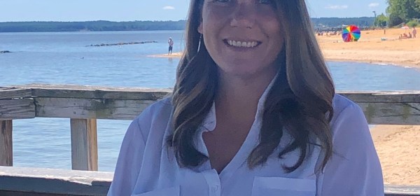 Young girl with long dark hair smiling.