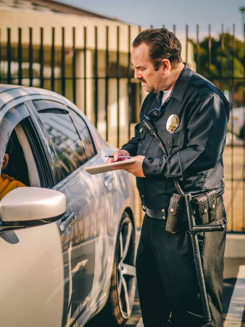 man in black and white long sleeve shirt standing beside silver car