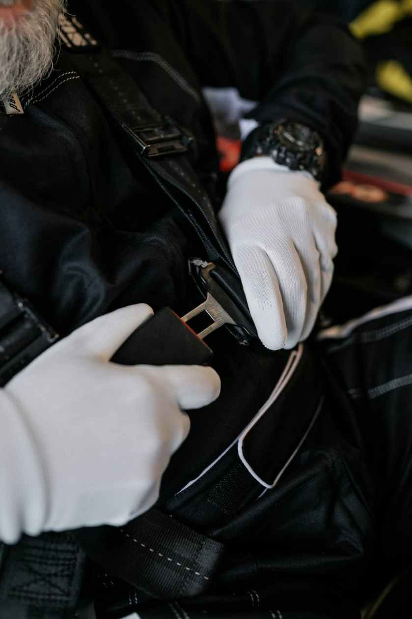 White gloved hands buckling a car seat belt.